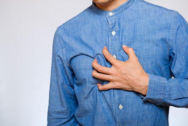 左手で胸をおさえる男性