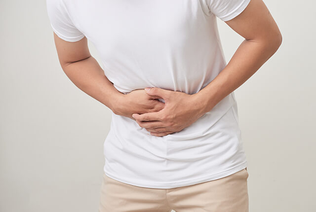 両手でお腹をおさえる男性